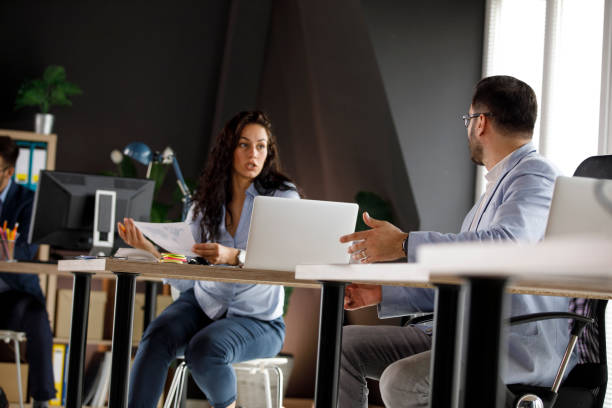 istock Two business colleagues sitting at their desks, discussing work problems 1333813296