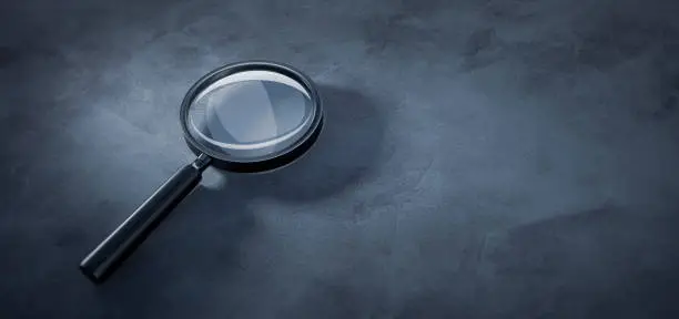 Photo of Magnifying glass on stone background