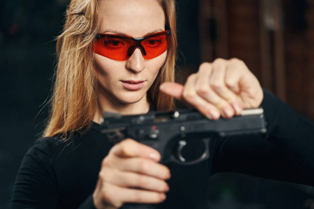 istock Focused experienced young woman reloading a handgun 1333814643