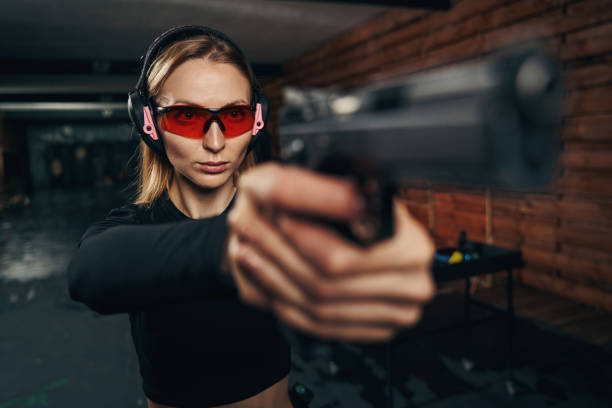 istock Focused beautiful shooter in earmuffs shooting a handgun 1333814664