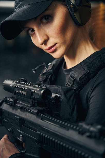 istock Serious woman sniper with a firearm posing for the camera 1333814709