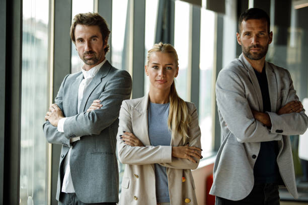 istock Three successful business colleagues standing with arms crossed, smiling at camera 1333816005