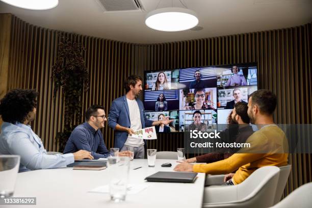 Group Of Businessmen Having A Video Conference Meeting With Their Coworkers Stock Photo - Download Image Now