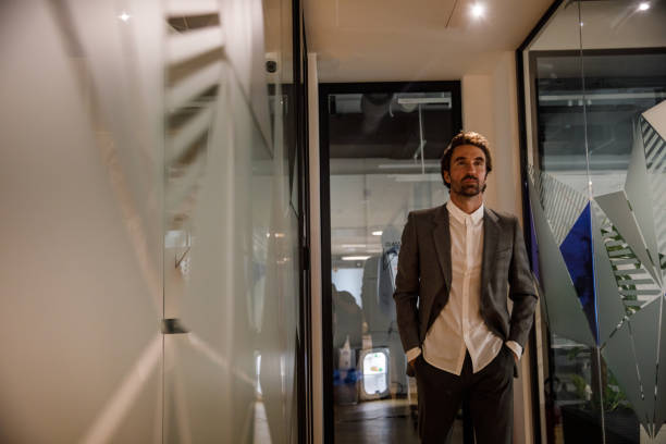 istock Businessman walking through the office hall with hands in pockets 1333816982