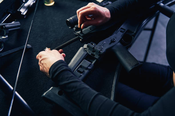 istock Skilled shooter assembling a gun part seated at the table 1333817365