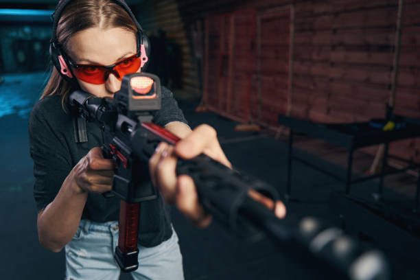 istock Experienced sniper in safety goggles and earmuffs shooting a firearm 1333817484