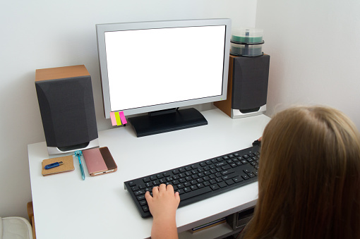 A girl is working on a computer in her room. White monitor screen template