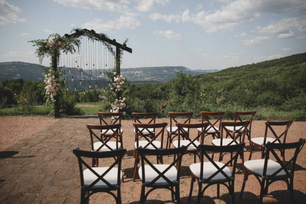 istock Wedding arch on boho style with white flowers in park with light bulbs. 1333820760