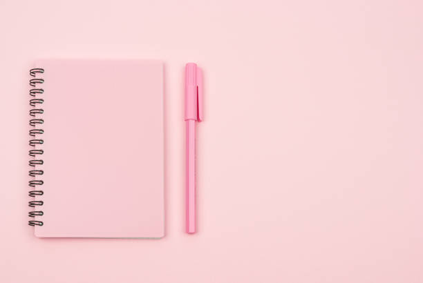 istock pink notebook and pink pen on a pink background 1333820908