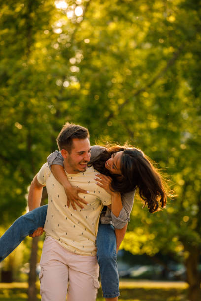 istock Couple in love doing a piggyback ride on a park walk 1333821208