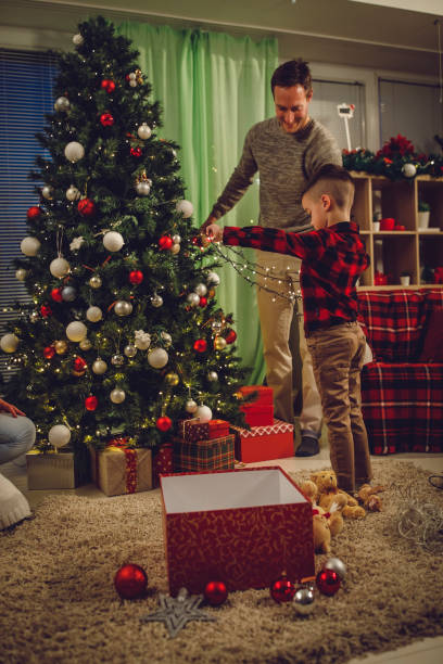 istock Little boy and his father detangling Christmas lights while decorating the Christmas tree 1333823854