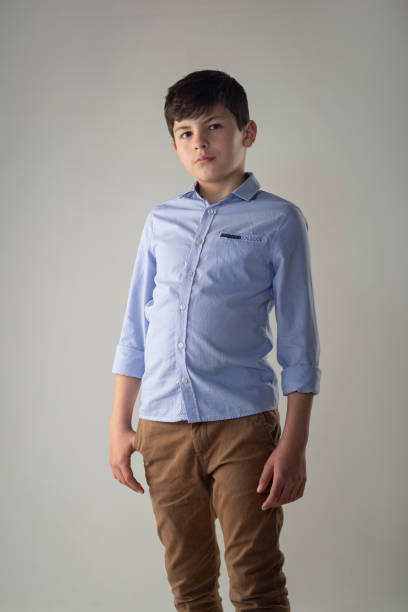 istock Boy looking at camera at photo shoot against white background. 1333824229