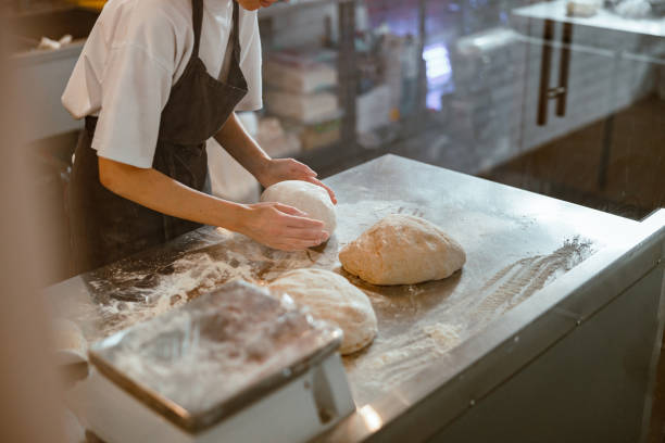 istock Baker kneads dough for bread at table in craft bakery shop closeup 1333825679
