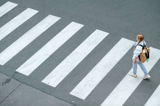 pupil crossing crosswalk and going to school outdoors in city stock photo