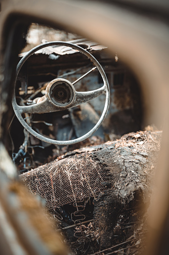 Steering wheel in a abandoned classic vintage car. Selective focus.