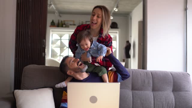 Man using laptop and wife and special needs son arriving at home