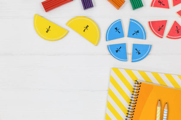istock Multicolored fractions, blocks, notebook on white wooden table. Back to school, fun math, games for kindergarten, preschool education. 1333834985