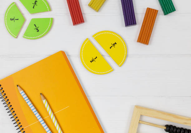 istock Multicolored fractions, blocks, notebook on white wooden table. Back to school, fun math, games for kindergarten, preschool education. 1333834990