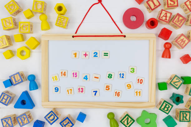 istock Multicolored fractions, blocks, notebook on white wooden table. Back to school, fun math, games for kindergarten, preschool education. 1333835496