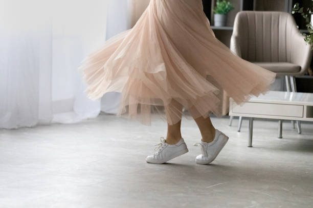 feet of young lady dancing on tiptoes at living room - skirt imagens e fotografias de stock