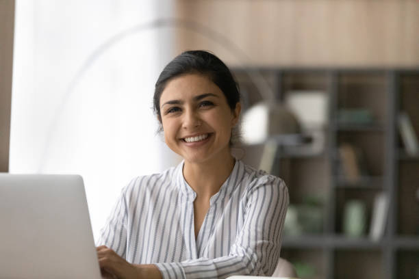 istock Portrait of cheerful ethnic woman using pc in office work 1333838152