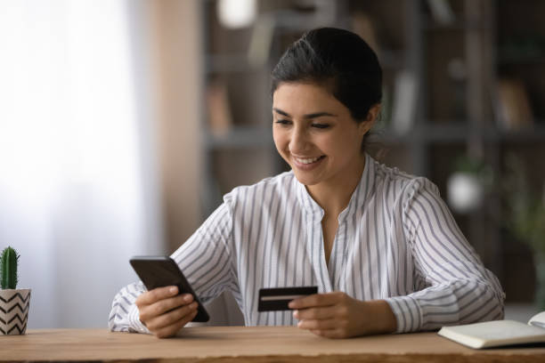 istock Confident ethnic female student pay tuition fee using mobile phone 1333838163