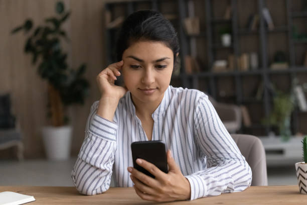 istock Serious millennial mixed race woman read text on smartphone screen 1333838165