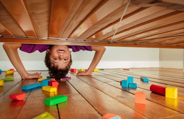 istock Boy look down under the bed stand on hands 1333838266