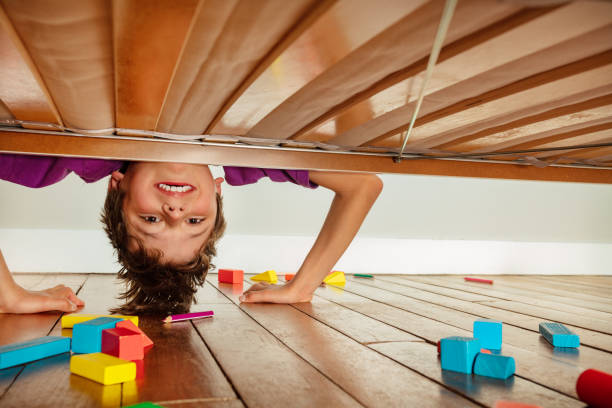 istock Boy look down under the bed make funny face 1333838278