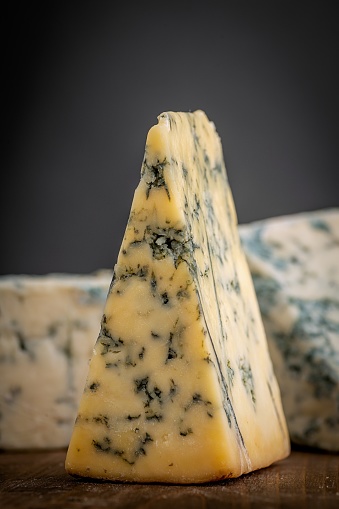 Close up of Pieces of Stilton Cheese over a wooden counter