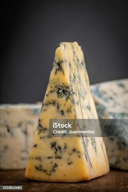 Pieces Of Stilton Cheese Over A Wooden Counter Stock Photo - Download Image Now - Roquefort Cheese, Stilton Cheese, Cheese