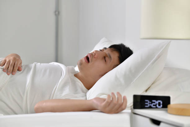 hombre asiático durmiendo y roncando - apnea del sueño fotografías e imágenes de stock