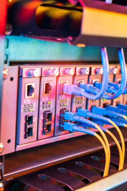 istock Fiber Optical cables connected to an optic ports and Network cables connected to ethernet ports 1333856012