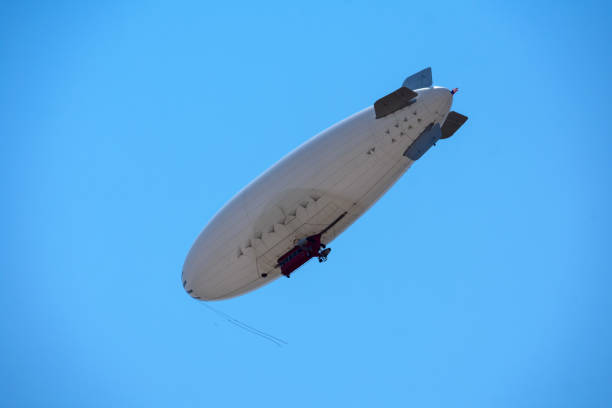 istock White blimp with red cabin flying in a blue sky 1333858577