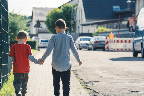 istock Brothers walk hand by hand on the sidewalk 1333860456