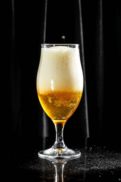 istock Frosty glass of light beer, craft beer with thick foam, vertical image. place for text 1333872492