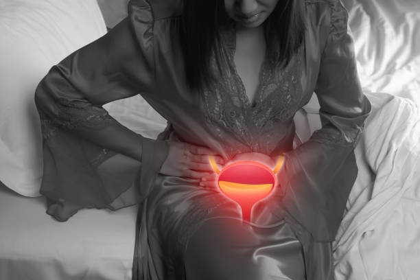 Cystitis symptoms with woman A woman having urethritis and Urinary Incontinence. Female in a satin nightgown with hands holding her crotch at night. Cystitis symptoms with woman bladder cancer stock pictures, royalty-free photos & images