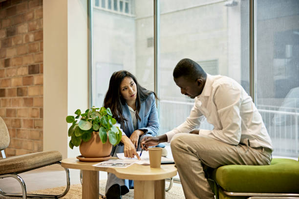 Real Estate Agent and Client Examining Property Floor Plans