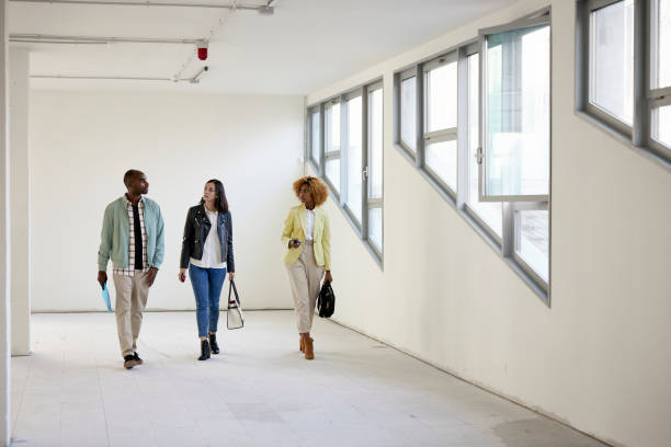 istock Real Estate Agent and Clients Touring Shell Condition Office Space 1333877317