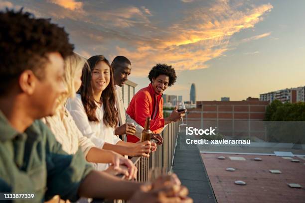 Coworkers Relaxing with Drinks After Work on Rooftop Deck