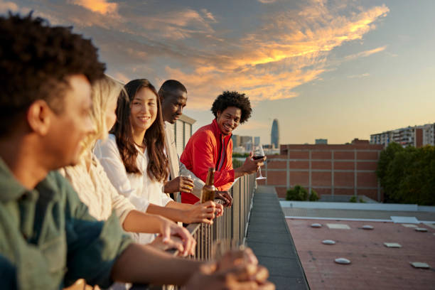 colegas relaxando com bebidas após o trabalho no deck do telhado - roof men business city - fotografias e filmes do acervo