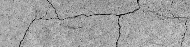 The rough texture of the cracked concrete, a backdrop of industrial material