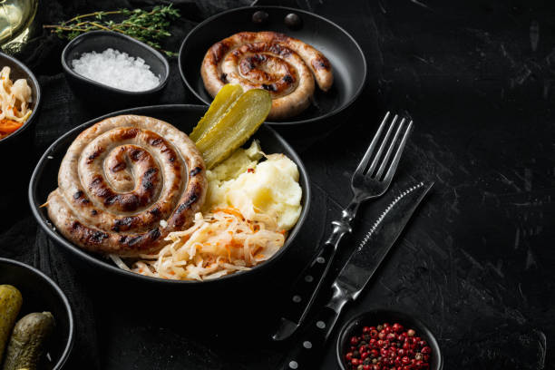 salsichas alemãs tradicionais com purê de batatas e chucrute, no fundo preto, com espaço para copyspace de texto - german culture salad prepared potato bratwurst - fotografias e filmes do acervo