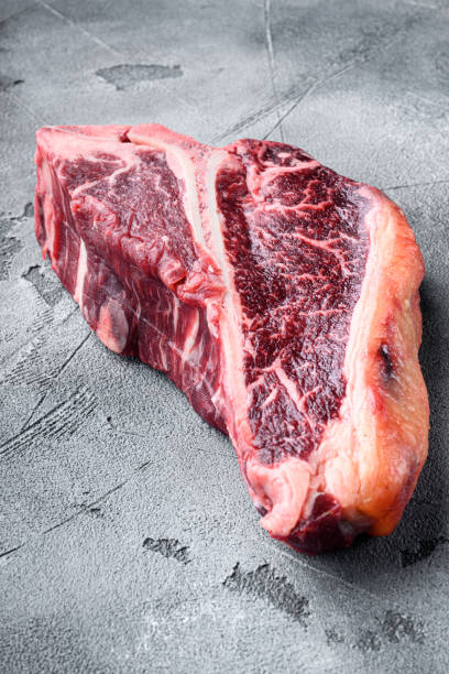 istock Prime cut tender raw t bone steak for a BBQ, on gray stone background 1333881734