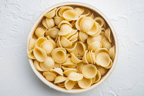 pasta almentica, su sfondo bianco, vista dall'alto - orecchiette foto e immagini stock