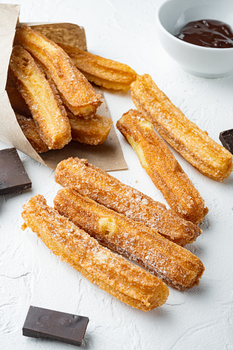 Traditional Spanish dessert churros with sugar and chocolate set, on white background