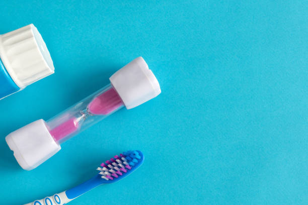 istock Blue background with a toothbrush and hourglass, kids brushing time 1333885166