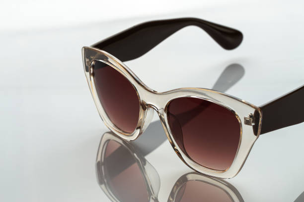 istock Sunglasses on a white reflective surface. Fashionable, stylish accessories. Use it for a vacation or summer concept. 1333886358