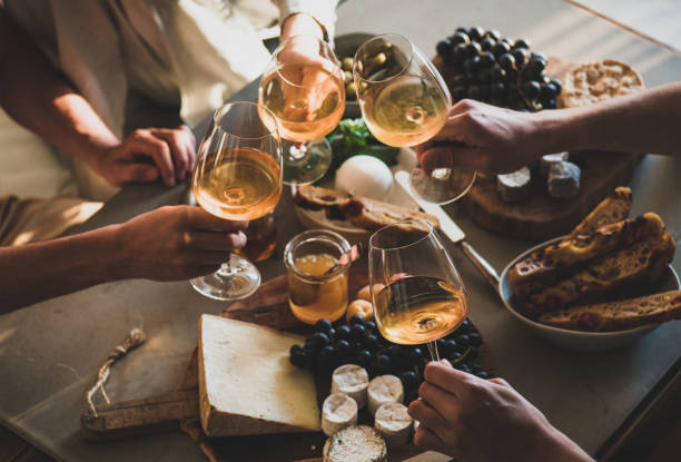 osoby trzymające kieliszki z winem pomarańczowym lub różawkowym nad przekąskami - toast party champagne dinner zdjęcia i obrazy z banku zdjęć