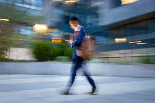 istock Businessman  rushing to the office, using phone 1333887656